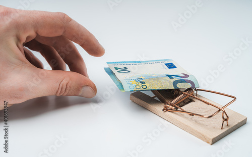 Isolated hands on white background grabbing for mousetrap with 20 euros banknote photo