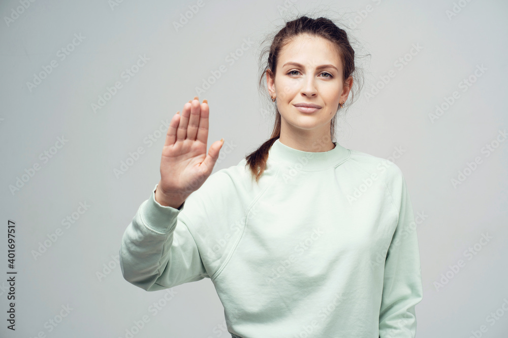 shows a hand gesture stop, looks at the camera brown-haired European appearance. photo studios on a gray white background. shows a hand gesture stop, looks at the camera brown-haired European appearance. photo studios on a gray white background.