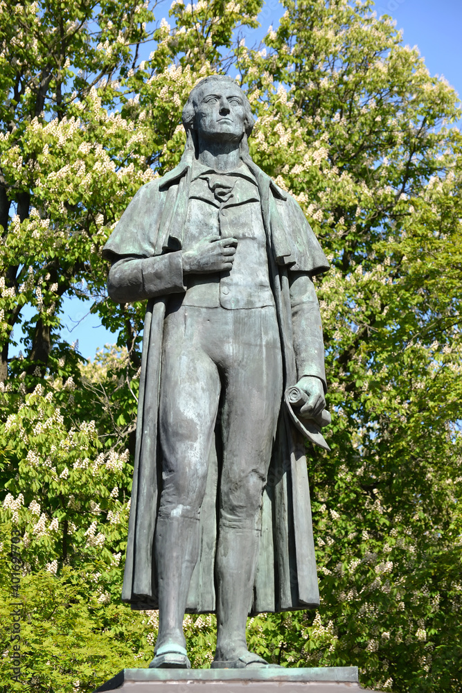 A sculpture by the German poet Friedrich Schiller (1759-1805) against the background of flowering chestnuts. Kaliningrad