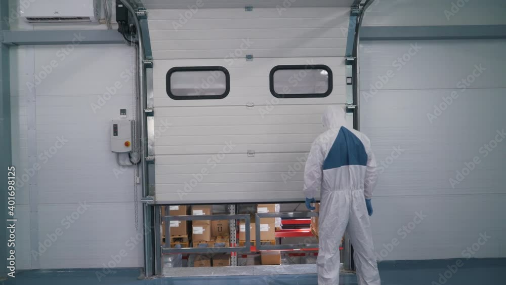 a worker in a special uniform opens a warehouse a worker in a special uniform opens a warehouse