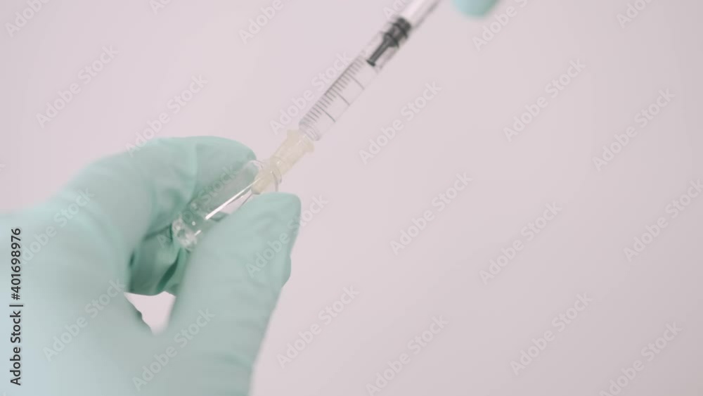 Vaccination concept. Doctor is going to do covid-19 vaccination to a patient. She is opening the ampula. Vaccination concept. Doctor is going to do covid-19 vaccination to a patient. She is opening the ampula.
