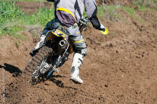 Unrecognized athlete riding a sports motorbike on a motocross racing