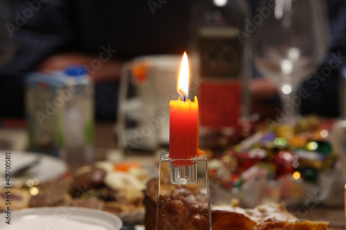 A burning candle on a festive table