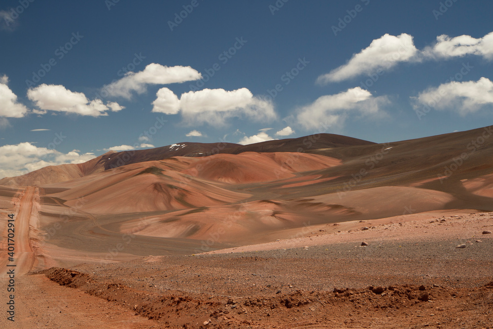 The dirt road high in the Andes mountains. Traveling along the route across the arid desert and mountain range. The sand and death valley under a deep blue sky in La Rioja, Argentina.