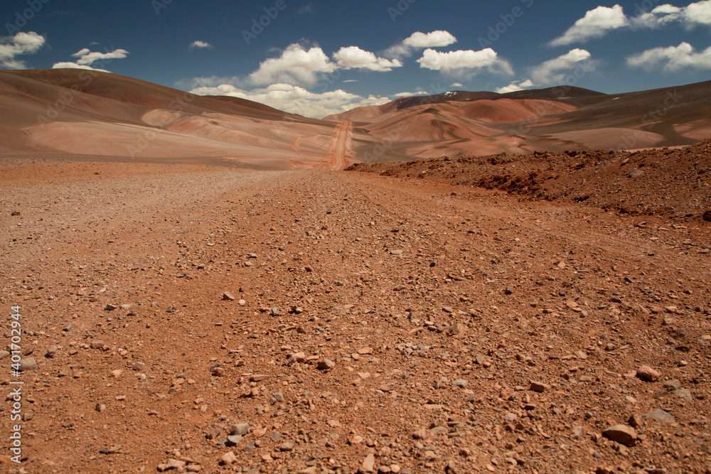 The dirt road high in the Andes mountains. Traveling along the route across the arid desert and mountain range. The sand and death valley under a deep blue sky in La Rioja, Argentina.