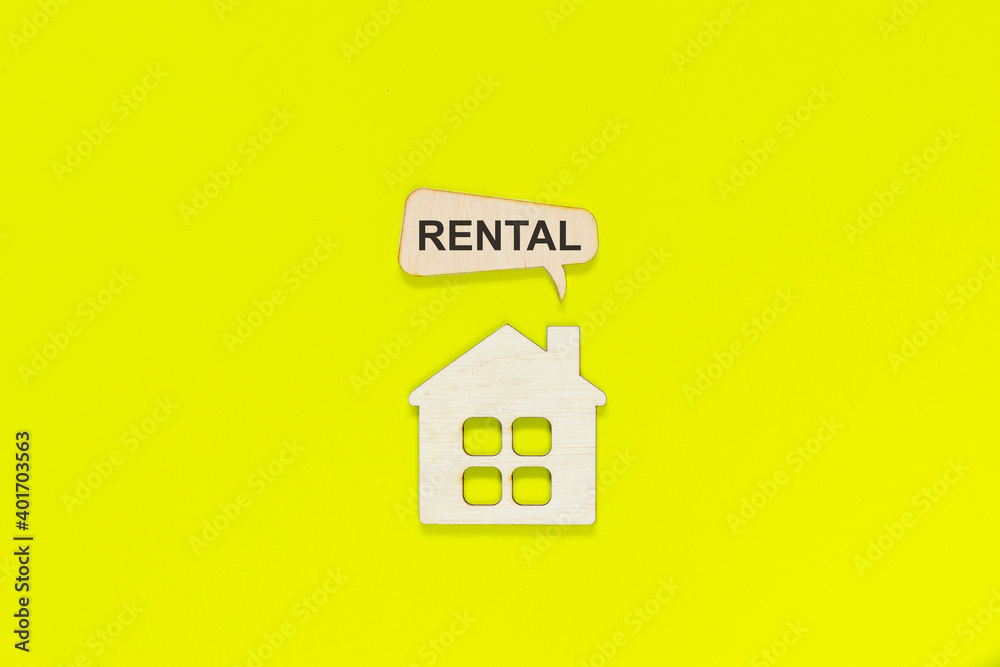 Figurine of a house with smoke from a chimney with the word rental on a yellow background. Business concept. Figurine of a house with smoke from a chimney with the word rental on a yellow background. Business concept.