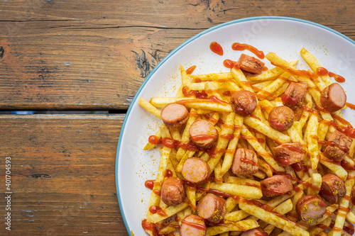 French fries with sausage, curry and ketchup