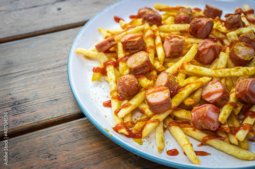 French fries with sausage, curry and ketchup