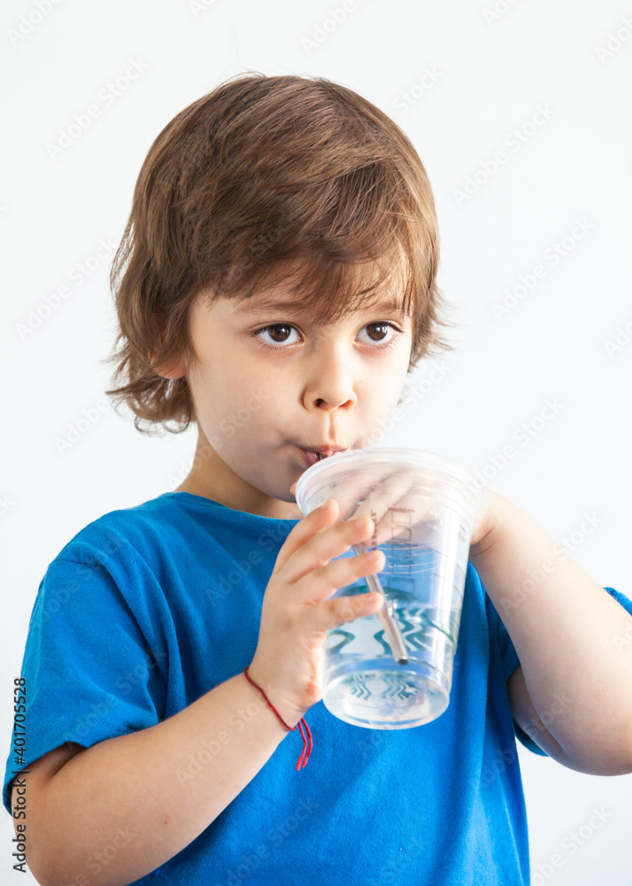portrait of a boy with a glass of water on a light background