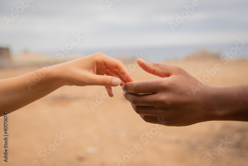 Close-up of the hands of an interracial couple touching. African and caucasian hands together. © Media Lens King