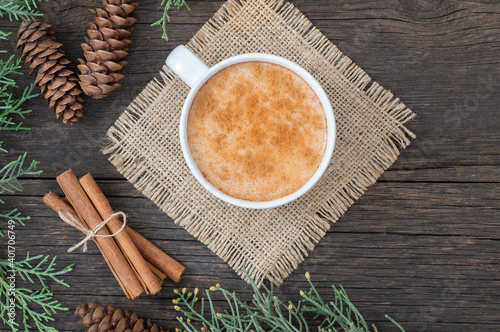 white cup of salep milky traditional hot drink of Turkey with cinnamon powder and sticks on rustic vintage wooden table. Sahlep background photo