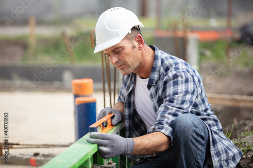 construction worker using spirit level on site