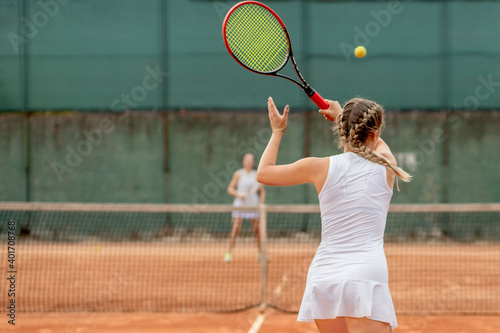 Tennis player in white sportswear preparing to serve tennis ball, training before match © volody10