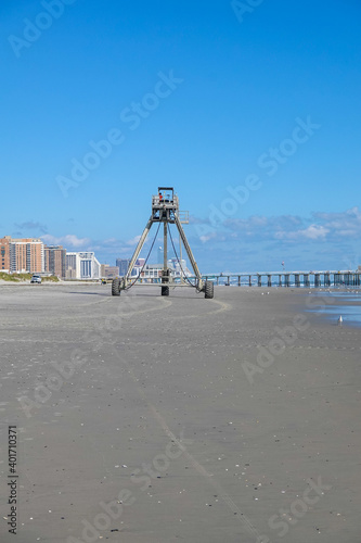 An amphibious buggy tower used for beach replenishment is seen rolling on the beach with Atlantic City casino buildings in the background
