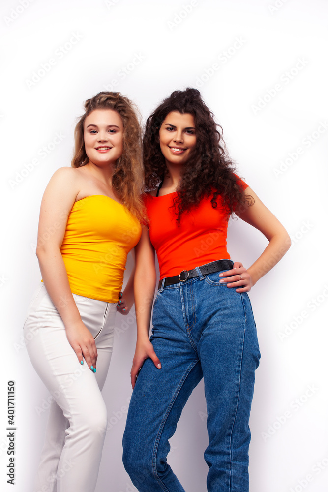 young pretty teenage girls friends with blond and brunette curly hairs posing cheerful isolated on white background, lifestyle people concept young pretty teenage girls friends with blond and brunette curly hairs posing cheerful isolated on white background, lifestyle people concept