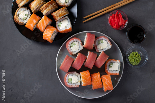 Asian food with sushi set of salmon, tuna and eel with philadelphia cheese on a dark background. Top view