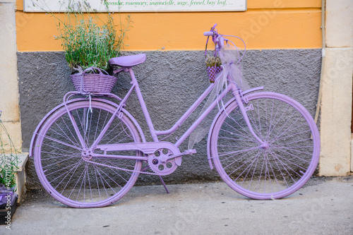 lilafarbenes Damenfahrrad vor einer Hauswand photo