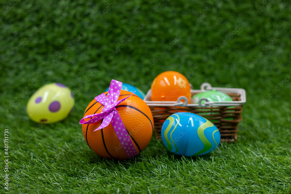 Basketball for Easter Holiday with ball and eggs in basket on green grass