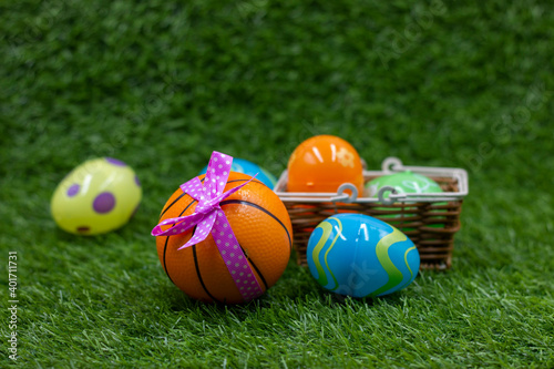 Basketball for Easter Holiday with ball and eggs in basket on green grass