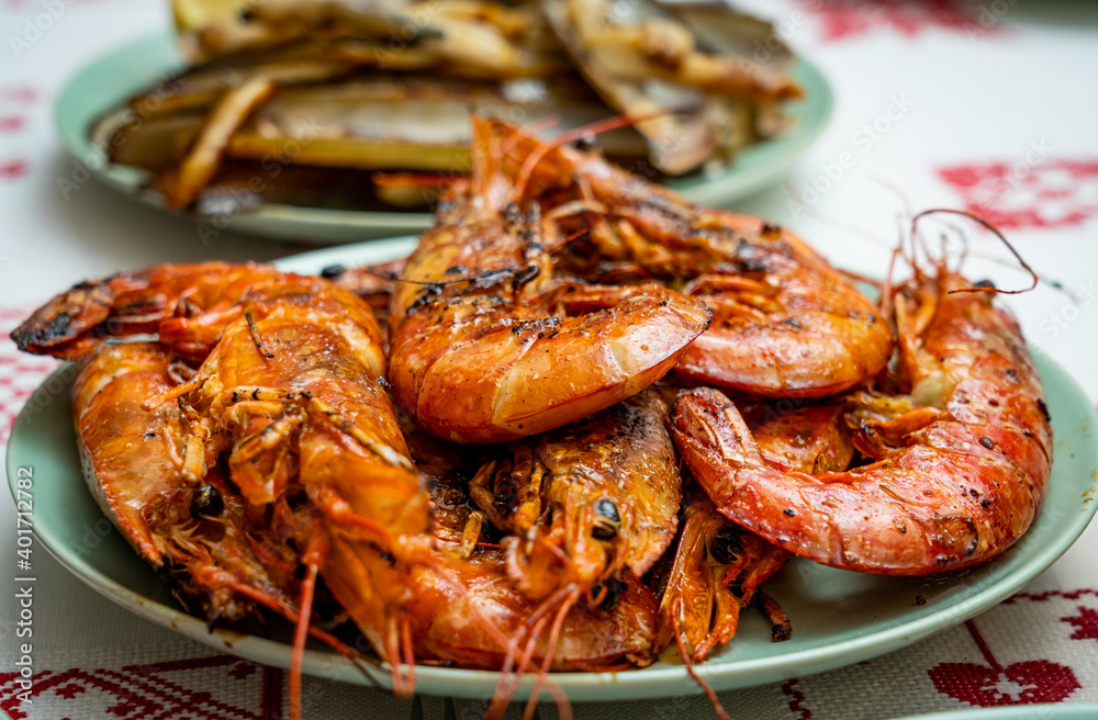 Fototapeta premium A closeup of deliciously cooked caridean shrimps with spices on a plate on the table