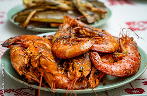 A closeup of deliciously cooked caridean shrimps with spices on a plate on the table