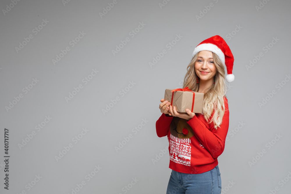 young beautiful woman in warm sweater and cristmas hat with a gift, picture isolated on white background young beautiful woman in warm sweater and cristmas hat with a gift, picture isolated on white background