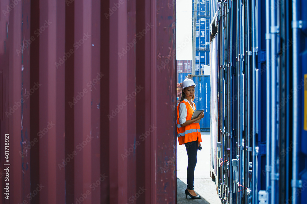 Young business woman or Cargo container woman container then use barcode scanner check the product and using tablet to monitor inventory while working in the container depot. for import and export Young business woman or Cargo container woman container then use barcode scanner check the product and using tablet to monitor inventory while working in the container depot. for import and export