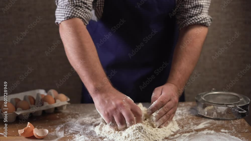 closeup male hands of a cook, begins to knead the dough from ingredients.Concept: production of sweets, pies, dough, delicacy, pure product, baking, work in restaurants, closeup male hands of a cook, begins to knead the dough from ingredients.Concept: production of sweets, pies, dough, delicacy, pure product, baking, work in restaurants,