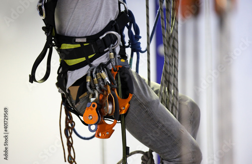 Safety rope access working at heights equipment, pulleys, hand ascender hanging on inspector harness 