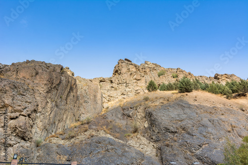 Tochal mountain ridge with rocks and trees in autumn against blue sky, Tehran, Iran. Tochal is a popular recreational region for Tehran's residents