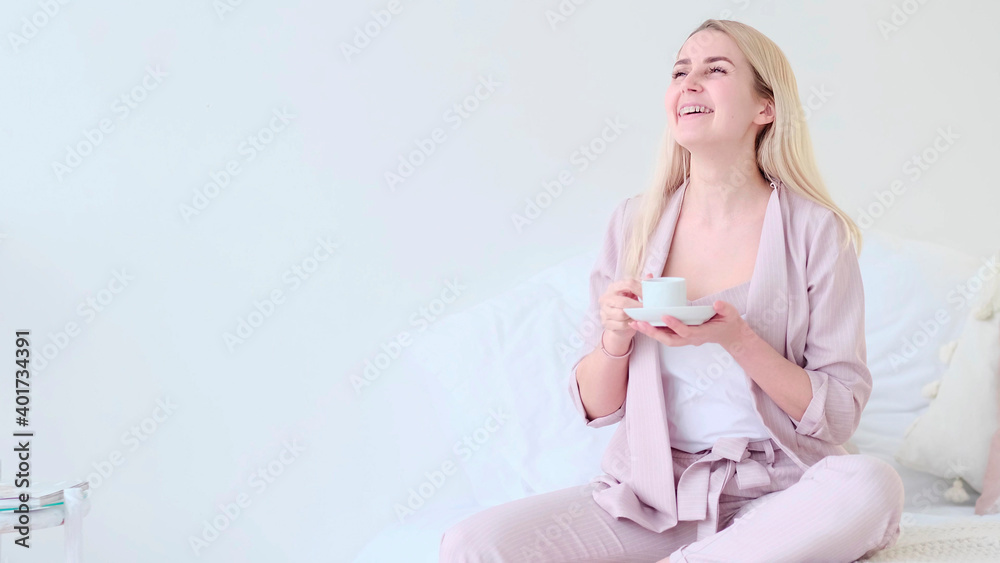 beautiful young woman with cup of coffee in a romantic setting. Front view woman with coffee cup looking at camera sitting on a couch. beautiful young woman with cup of coffee in a romantic setting. Front view woman with coffee cup looking at camera sitting on a couch.
