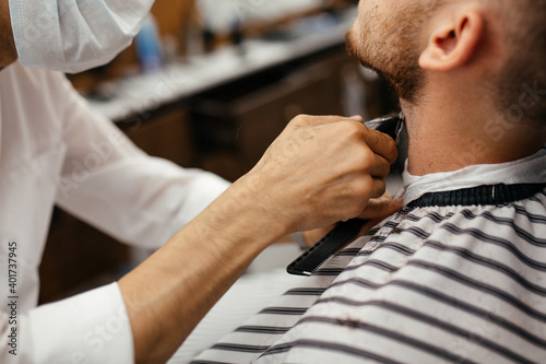 a man has hair cut on his beard in a barber shop