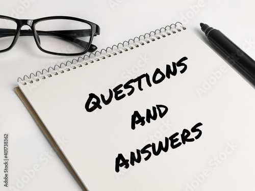 Text QUESTIONS AND ANSWERS on notebook with marker pen and eye glasses.Business concept.