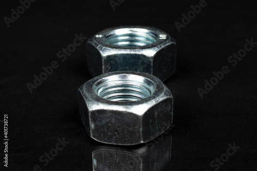 several large metal nuts on a black background