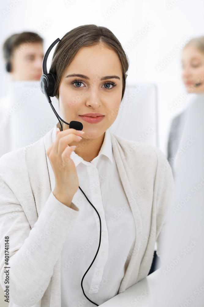 Call center. Group of diverse operators at work. Beautiful woman in headset communicating with customers of telemarketing service. Business concept Call center. Group of diverse operators at work. Beautiful woman in headset communicating with customers of telemarketing service. Business concept