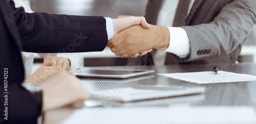 Handshake as successful negotiation ending, close-up. Unknown business people shaking hands after contract signing in modern office © Iryna
