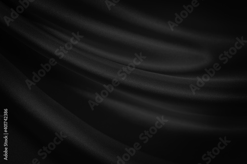 Abstract black background. Black silk satin texture background. Beautiful soft folds on the fabric. Black elegant background with copy space for your design.