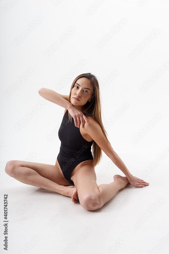 sexy asian woman with long hair posing in black lingerie on white studio background with bare feet. attractive female sitting on floor with her knees bent. model tests of skinny lady in bodysuit sexy asian woman with long hair posing in black lingerie on white studio background with bare feet. attractive female sitting on floor with her knees bent. model tests of skinny lady in bodysuit