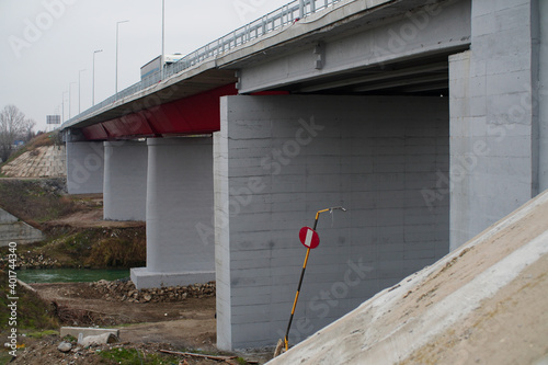 A closeup of a row gray bridge piles under a bridge photo