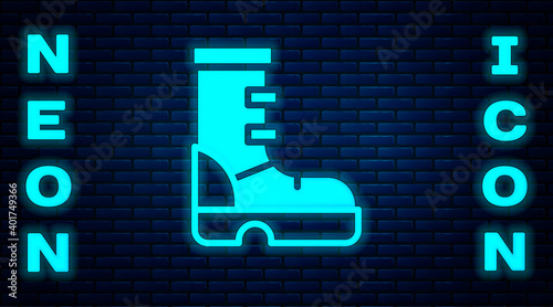 Glowing neon Waterproof rubber boot icon isolated on brick wall background. Gumboots for rainy weather, fishing, gardening. Vector.