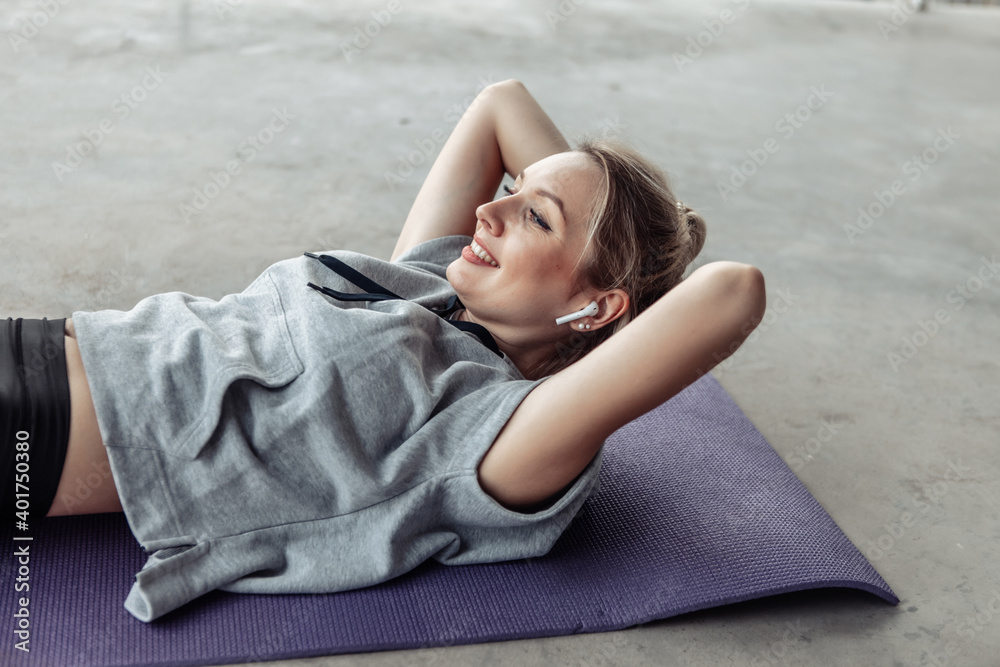 Urban style training abdominal muscles of a young fit woman lying on a mat. Healthy lifestyle