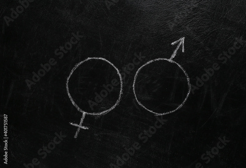 Gender female and male symbol hand drawn in chalk on a blackboard