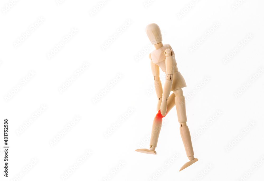 Wooden puppet with leg pain isolated on white background. Osteoarthritis Wooden puppet with leg pain isolated on white background. Osteoarthritis