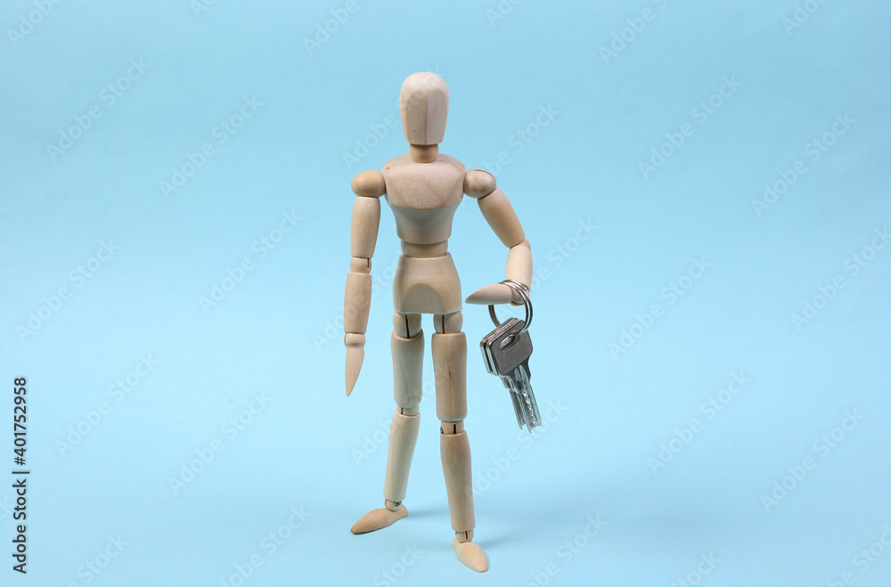 Wooden puppet holds keys on blue background. Wooden puppet holds keys on blue background.