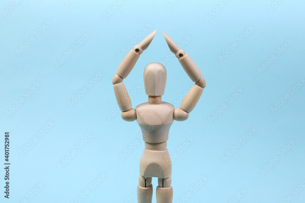 A wooden puppet holds arms above its head. Protection concept A wooden puppet holds arms above its head. Protection concept
