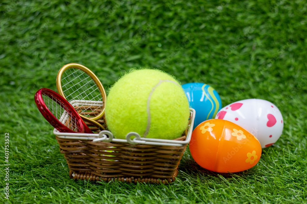 Tennis ball for Easter Holiday with eggs on green grass