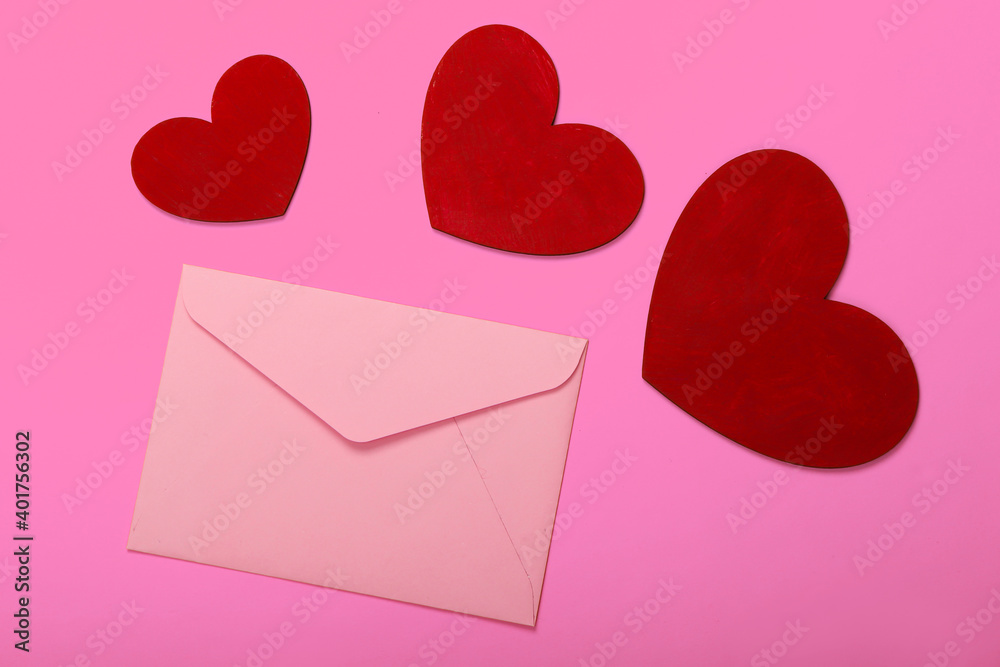 Envelope with red hearts (valentines) on pink background. Valentine's Day. Top view