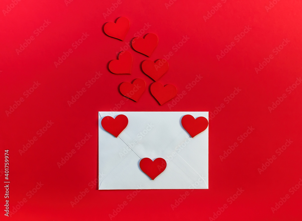 Valentine's day romantic concept. Red wooden hearts and envelop on red background.