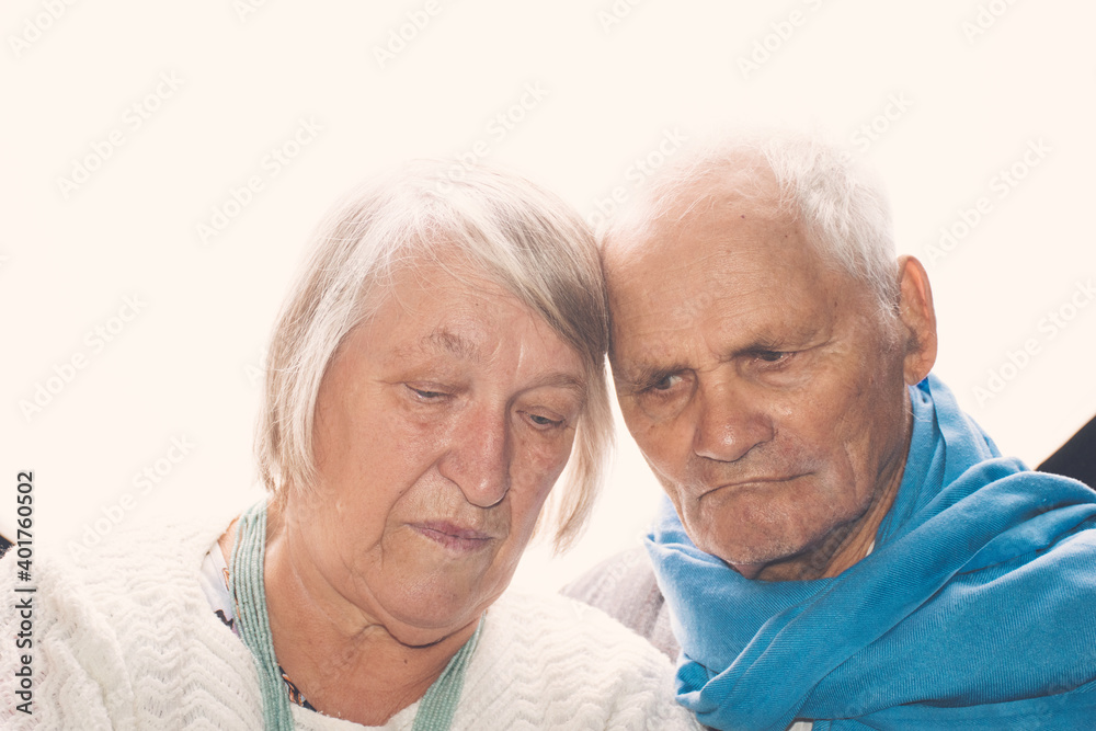Backlight closeup portrait of happy old couple posing head to head on white background; concept of love, long-term relationships and family bonds Backlight closeup portrait of happy old couple posing head to head on white background; concept of love, long-term relationships and family bonds