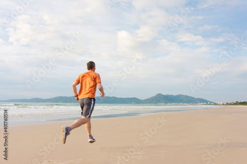 Mature man running on a long beach early in the morning
